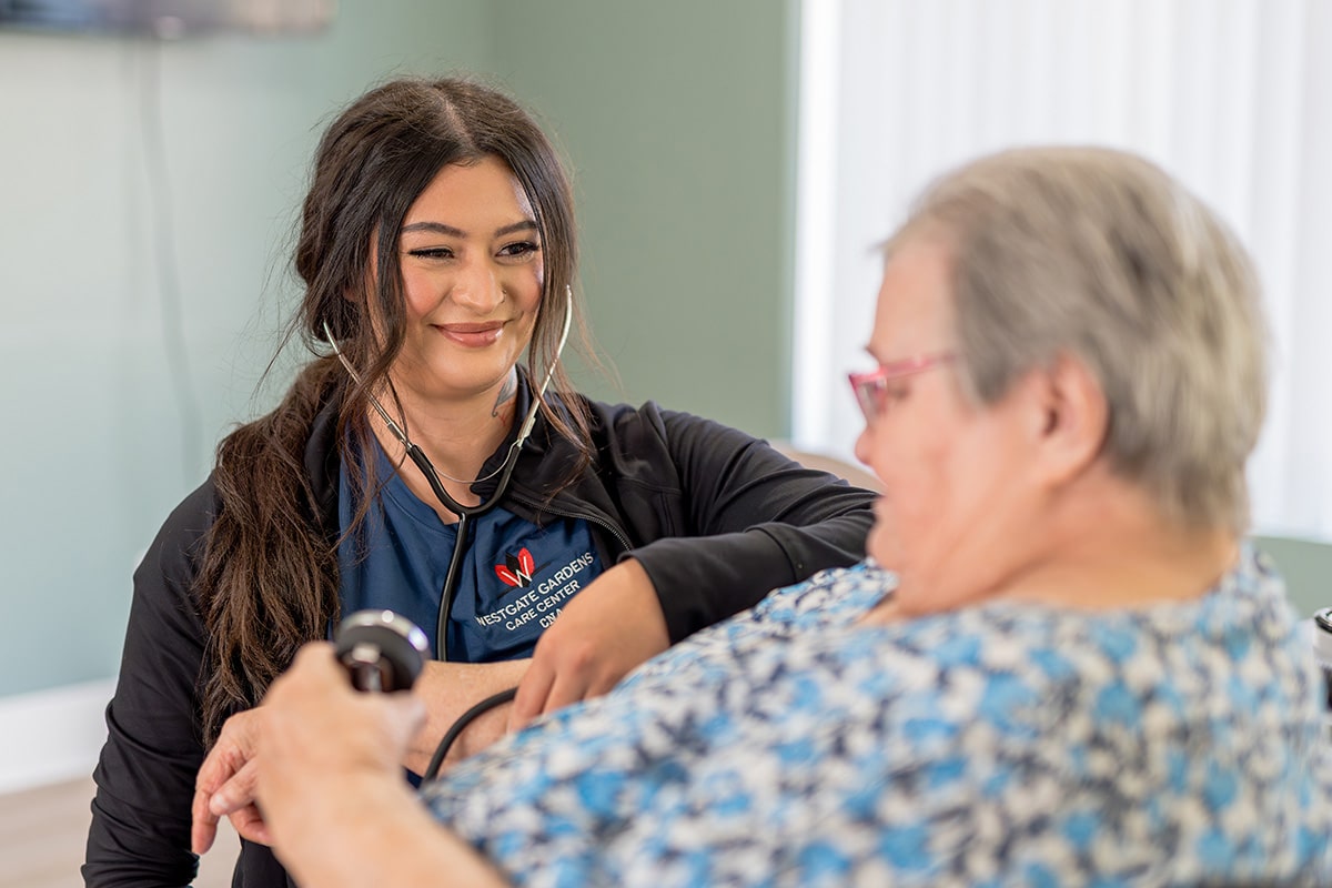 A nurse taking a woman's heart beat